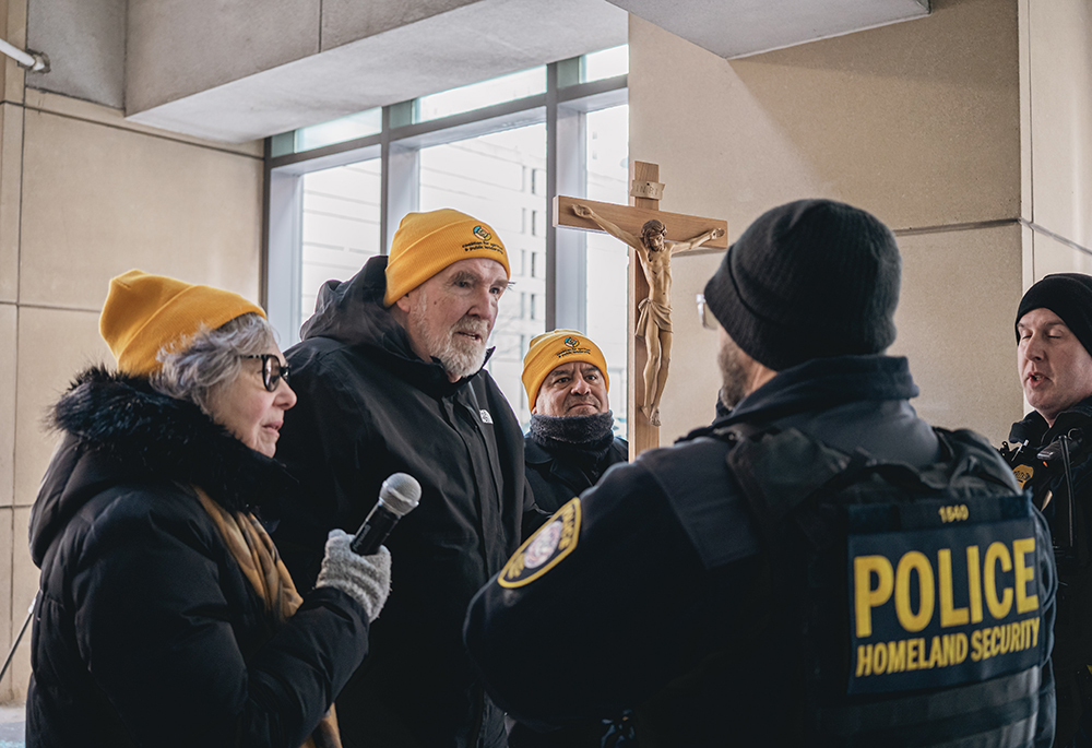Fr. Dennis Berry, center, and Felician Sr. Jeremy Midura, left, talk to a Department of Homeland Security official outside the U.S. Immigration and Customs Enforcement's Chicago field office, Dec. 19. (Courtesy of Coalition for Spiritual and Public Leadership/Bryan Sebastian)
