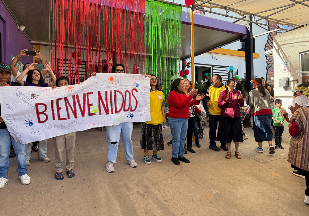 Staff and volunteers of the nonprofit Kino Border Initiative in Nogales, Mexico, welcome participants in a traditional posada procession to a holiday celebration with food and mariachi music on Dec. 20. (Anita Snow)