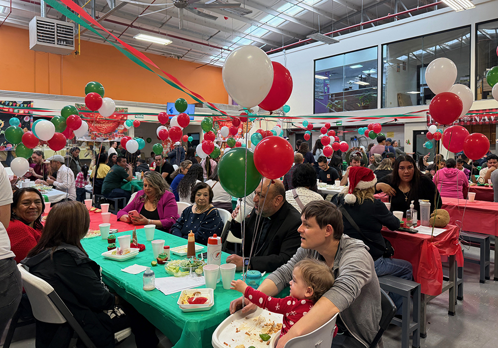 Migrants, staff, volunteers and friends enjoy a holiday meal at the Catholic-run migrant charity Kino Border Initiative headquarters following a traditional posada procession in Nogales, Mexico, on Dec. 20. (Anita Snow)