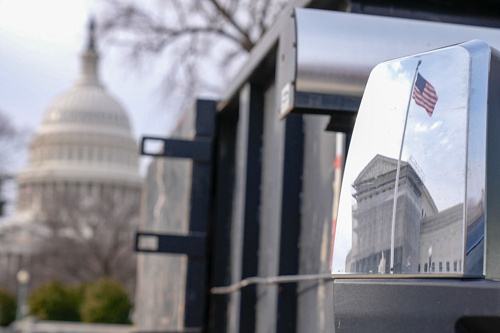 The reflection of the U.S. Supreme Court is seen as the U.S. Capitol, left, is visible Dec. 12, 2025, in Washington. (AP/Mariam Zuhaib)