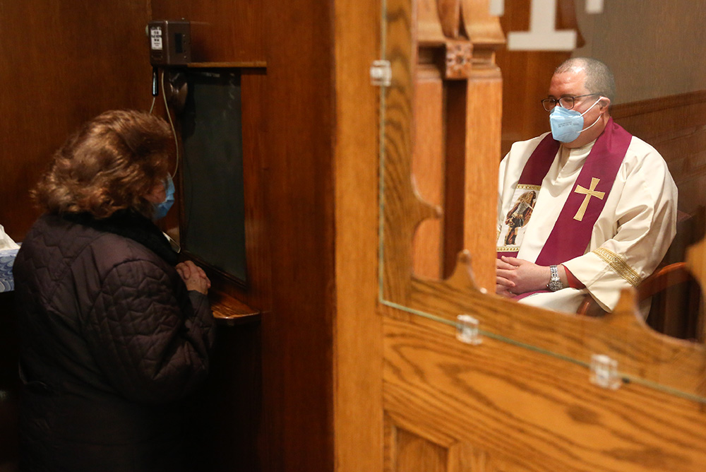 Fr. Manuel Rodríguez listens to a parishioner's confession at Our Lady of Sorrows in the Queens borough of New York on Saturday, March 20, 2021. (AP/Jessie Wardarski)