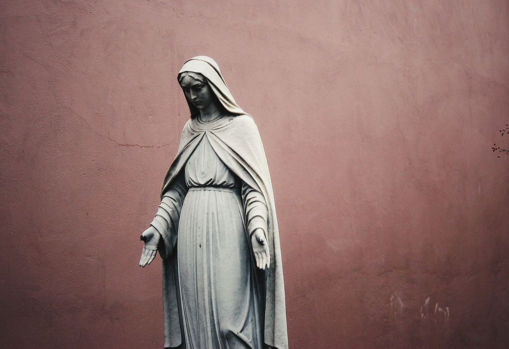 A photo shows a gray statue of Mary. (Unsplash/Jon Tyson)