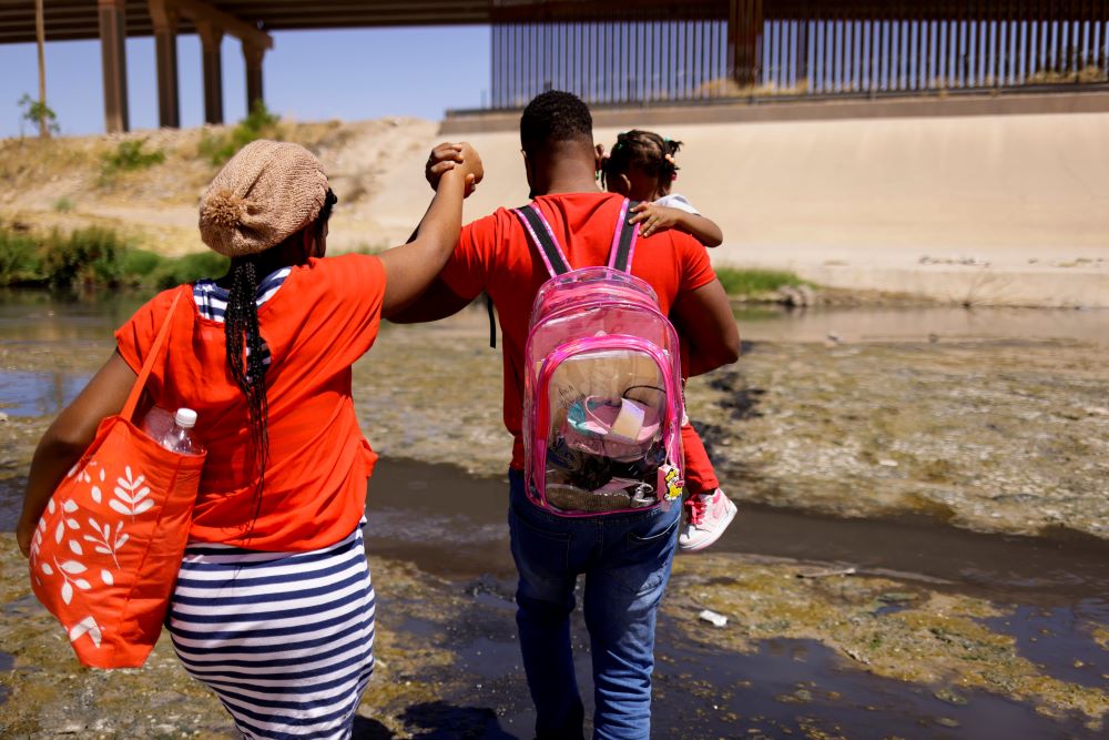 An asylum-seeking migrant family from Haiti cross the Rio Bravo to turn themselves in to U.S Border Patrol agents to request asylum in El Paso, Texas, as seen from Ciudad Juarez, Mexico, April 22, 2022. (OSV News/Reuters/Jose Luis Gonzalez)