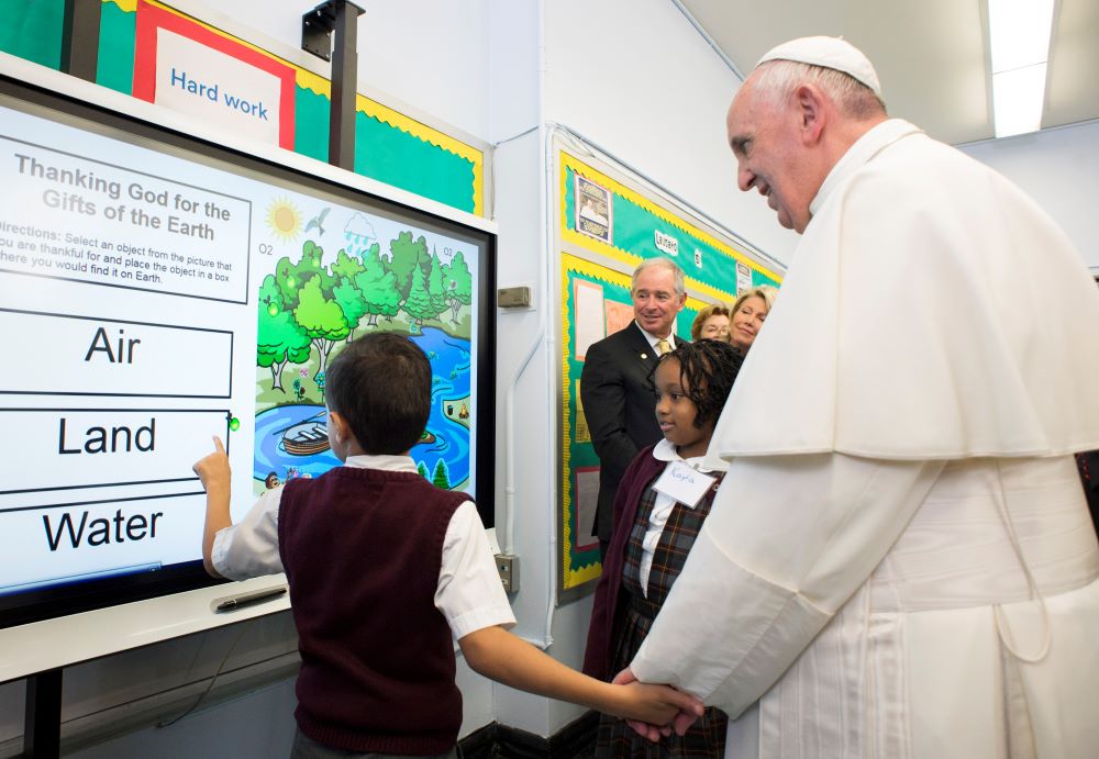 A student shows Pope Francis a lesson on the environment during his visit to Our Lady Queen of Angels School in the East Harlem area of New York Sept. 25, 2015. (CNS)
