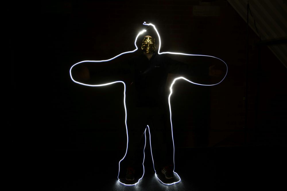 image shows person on back background, with white light outlining the body (Unsplash/Richard Sausage)
