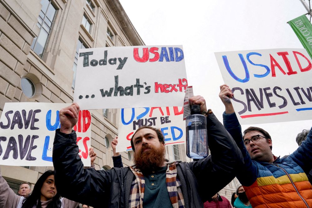 People hold placards outside the U.S. Agency for International Development building in Washington Feb. 3, 2025, protesting the Trump administration's moves to shut down the U.S. foreign aid agency. (OSV News/Reuters/Kent Nishimura)