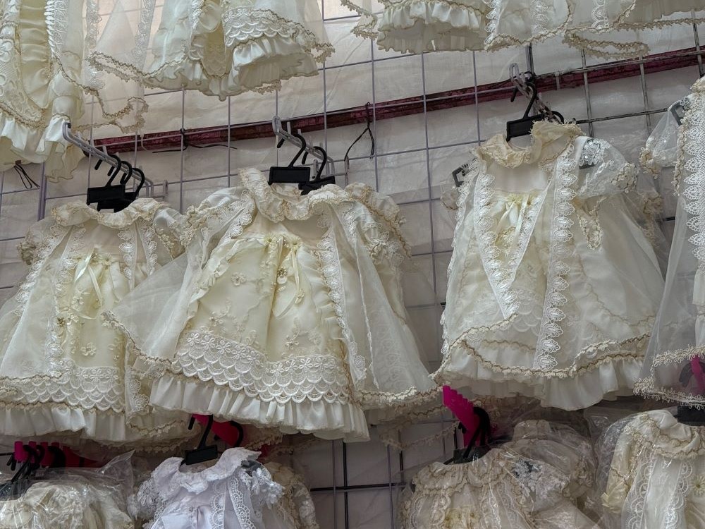 Traditional white gowns worn by Baby Jesus figurines on Candlemas for their presentation for a blessing at church hang Jan. 27 in a Mexico City market dedicated to the sale, repair and dressing of the plaster dolls. (Anita Snow)
