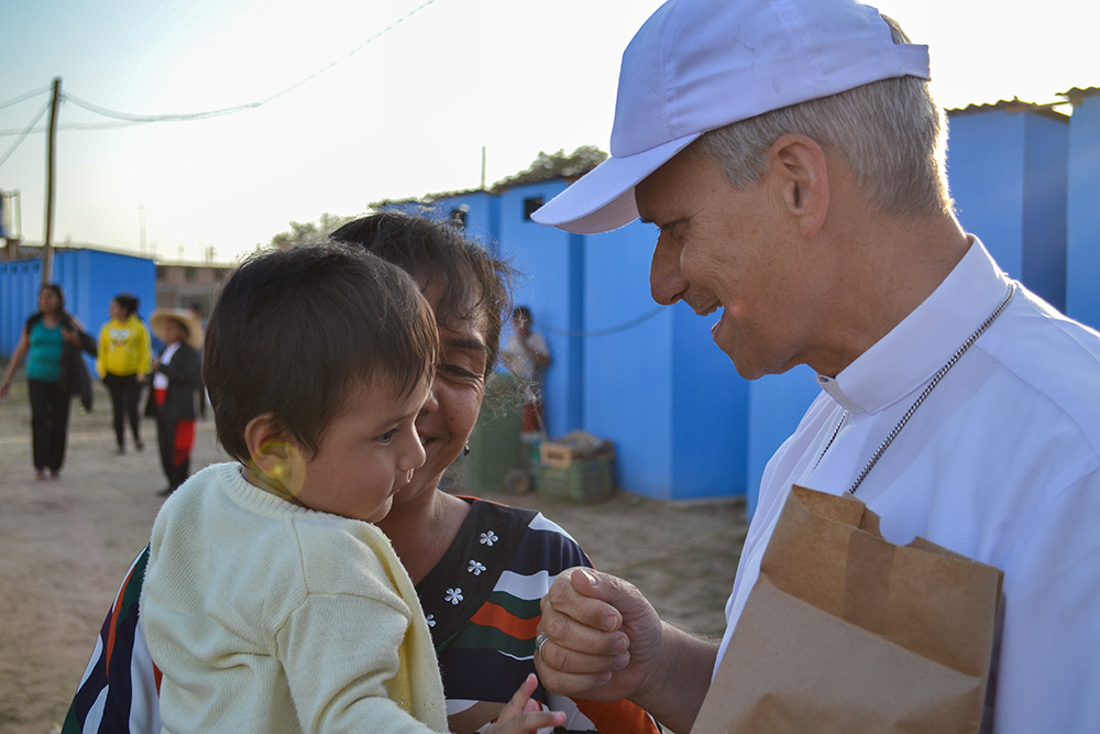 Then-Bishop Robert Prevost of Chiclayo, Peru, gives a bag of food to a family in need during an event organized by Caritas Chiclayo to assist the poor Nov. 20, 2017. (Courtesy of Janina Sesa)