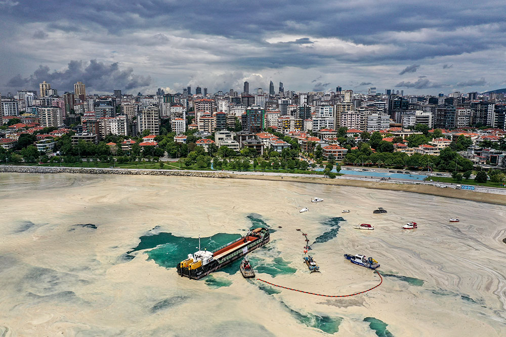 Sea-surface-cleaning vessels and barrier-laying boats of Istanbul clean up a thick, slimy layer of the organic matter known as marine mucilage June 15, 2021. (CNS/Reuters/Umit Bektas)