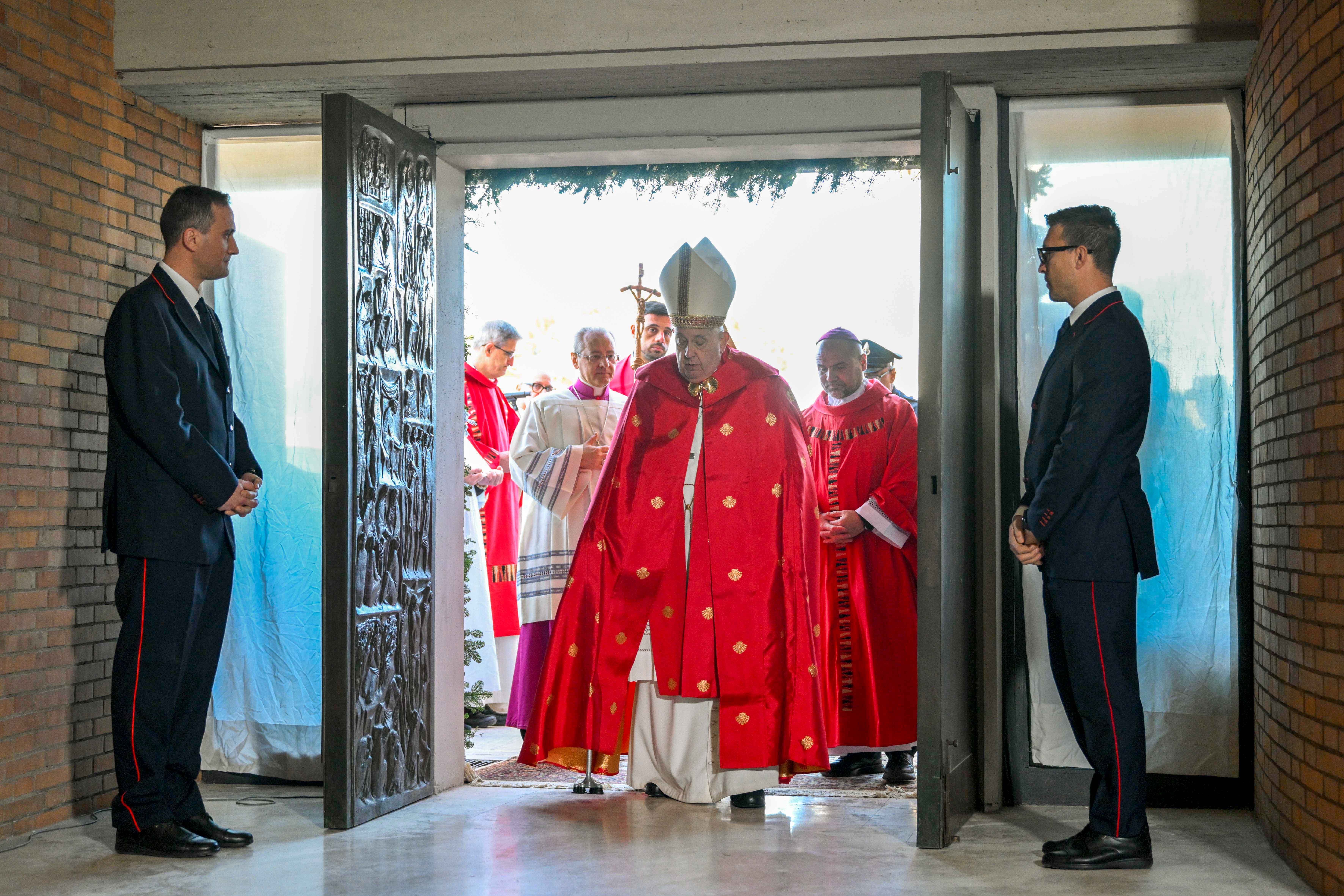Pope Francis crosses the threshold of the Holy Door of the Church of Our Father at Rome's Rebibbia prison Dec. 26, 2024, before presiding over a Mass with inmates, prison staff and Italian government officials. (CNS photo/Vatican Media)