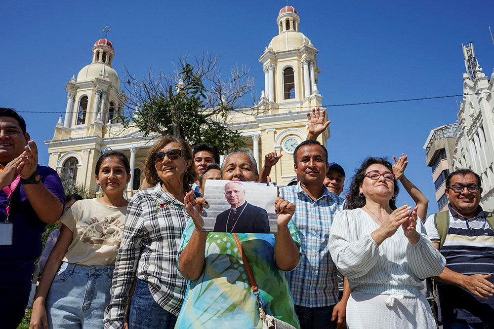 A woman holds an image of then-Cardinal Robert Francis Prevost in front of the Cathedral of St. Mary in Chiclayo, Peru, May 8, 2025, after he was elected pope at the Vatican and chose the name Leo XIV. He served as bishop of Chiclayo from 2015 to 2023. (OSV News/Reuters/Diego Torres Menchola)