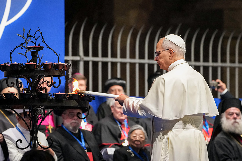 Pope Leo XIV lights a candle during an international gathering for peace attended by leaders of Christian communities and other world religions at the Colosseum in Rome Oct. 28, 2025. The annual International Meeting of Dialogue and Prayer for Peace was organized by the Rome-based Community of Sant'Egidio. (CNS/Lola Gomez)