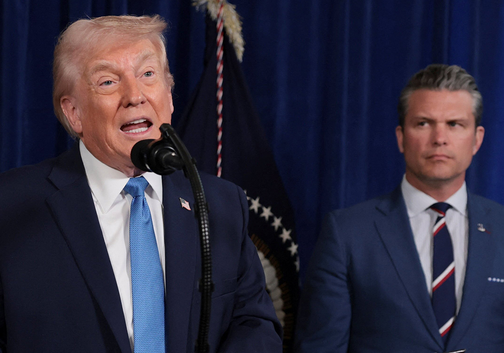 U.S. President Donald Trump speaks from Trump's Mar-a-Lago club in Palm Beach, Florida, 2026, as Secretary of Defense Pete Hegseth looks at him during a news conference following a U.S. strike on Venezuela where President Nicolás Maduro and his wife, Cilia Flores, were captured. (OSV News/Reuters/Jonathan Ernst)