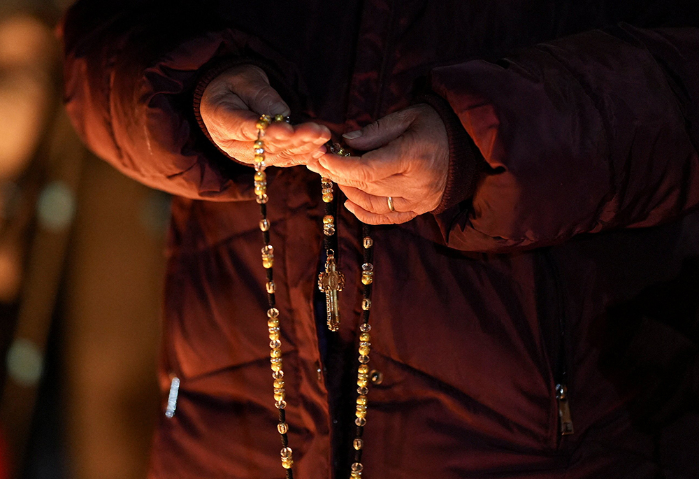 A woman holds a rosary during a vigil for a 37-year-old woman who was shot in her car by a U.S. immigration agent, according to local and federal officials, in Minneapolis Jan. 7, 2026. (OSV News/Reuters/Tim Evans)
