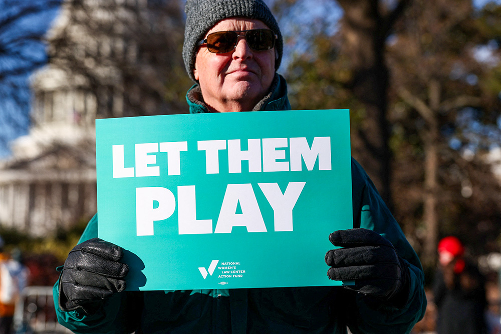 A transgender rights supporter holds a placard outside the U.S. Supreme Court in Washington Jan. 13, 2026. (OSV News/Reuters/Kevin Lamarque)