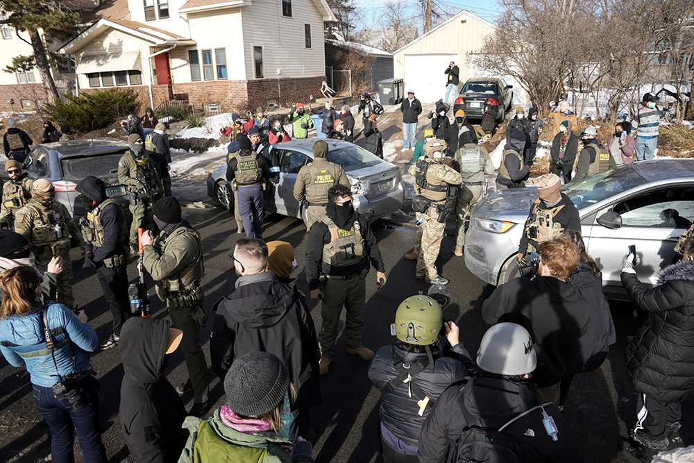 Federal agents stand by a damaged civilian's car hit by U.S. Immigration and Customs Enforcement agents in Minneapolis Jan.12, 2026, during ongoing demonstrations against ICE. (OSV News/Reuters/Tim Evans)