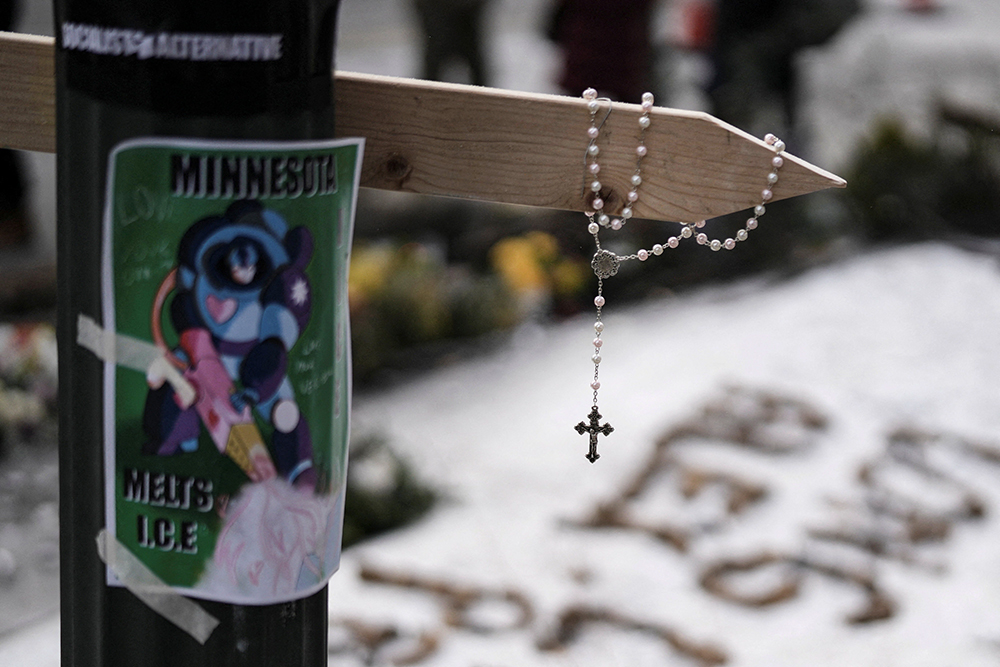 A rosary hangs from a cross at a makeshift memorial in Minneapolis Jan. 25, 2026, at the site where Alex Pretti, a 37-year-old intensive care nurse, was fatally shot by federal agents Jan. 24. (OSV News/Reuters/Tim Evans)