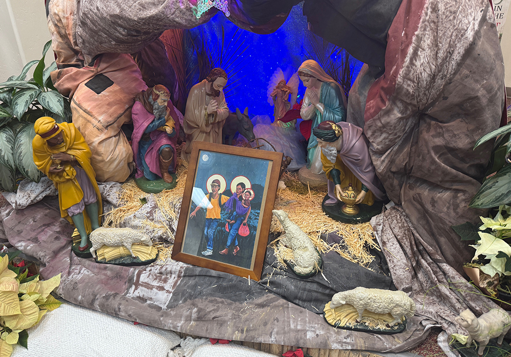 A painting of a migrant father, mother and child depicted as the Holy Family sits on the Nativity scene during a Three Kings Day celebration in Tucson, Arizona, on Jan. 4, 2026. (Anita Snow)