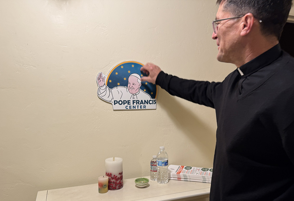 Jesuit Fr. Scott Santarosa, the pastor of Our Lady of Guadalupe Parish in San Diego, points out the Pope Francis Center's logo in the front entrance of the building. (Anna Weaver)