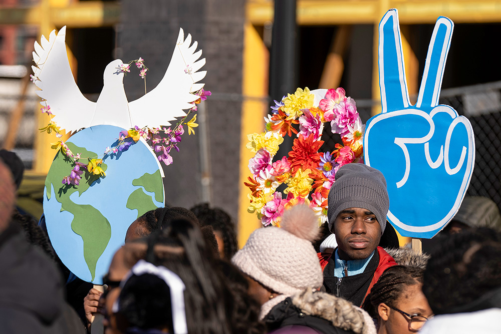 Los participantes sostienen símbolos de paz mientras se reúnen antes del desfile anual del Día de Martin Luther King en el Distrito de Columbia, el 19 de enero de 2026, en Washington, Estados Unidos. (Foto: AP/Mark Schiefelbein)