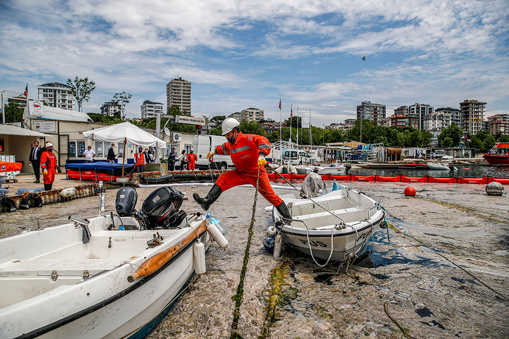 An expert works to clear a mass of marine mucilage, a thick, slimy substance made up of compounds released by marine organisms, from Türkiye's Sea of Marmara at the Caddebostan shore, on the Asian side of Istanbul, June 8, 2021. (AP/Kemal Aslan)
