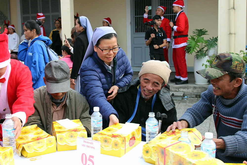 Daughters of Mary of the Immaculate Conception Sr. Mary Teresa Pham Thi Lai (center) distributes Christmas cakes to people affected by natural disasters at her community in Hue, Vietnam, Dec. 23, 2025. (Joachim Pham)