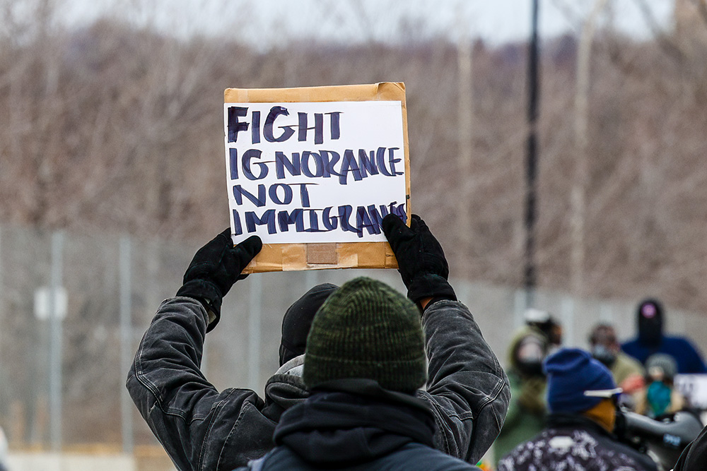 A protester holds a handmade sign reading, "Fight Ignorance Not Immigrants," during a demonstration at Fort Snelling, Minnesota, Jan. 15, 2026. (Dreamstime/Ruhuntn)