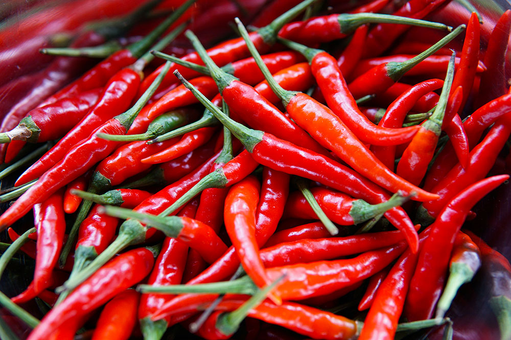 Closeup of a pile of red chili peppers (Unsplash/Elle Hughes)