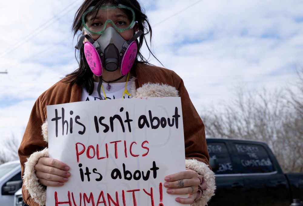Elizabeth Anne Jolly holds a sign as she protests hours after 5-year-old Liam Conejo Ramos and his father, Adrian Conejo Arias, returned home after a judge ordered them to be released from Immigration and Customs Enforcement detention at the South Texas Family Residential Center in Dilley, Texas, Feb. 1. (OSV News/Reuters/Kaylee Greenlee)