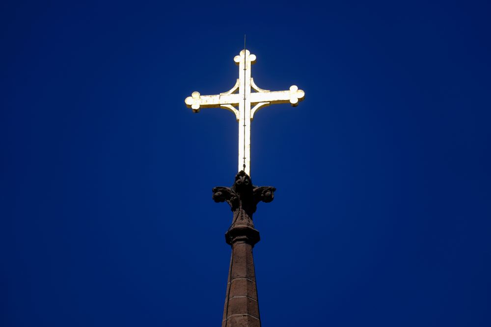 A cross is silhouetted against a stained glass window inside a Catholic Church in New Orleans on Dec. 1, 2012. (AP/Gerald Herbert, file)