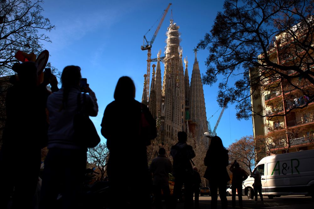People watch as a crane lifts the upper arm of the cross onto the Tower of Jesus Christ at the Sagrada Familia in Barcelona, Spain, Feb. 20, reaching the basilica's maximum height of 172.5 meters (566 feet). (AP/Emilio Morenatti)