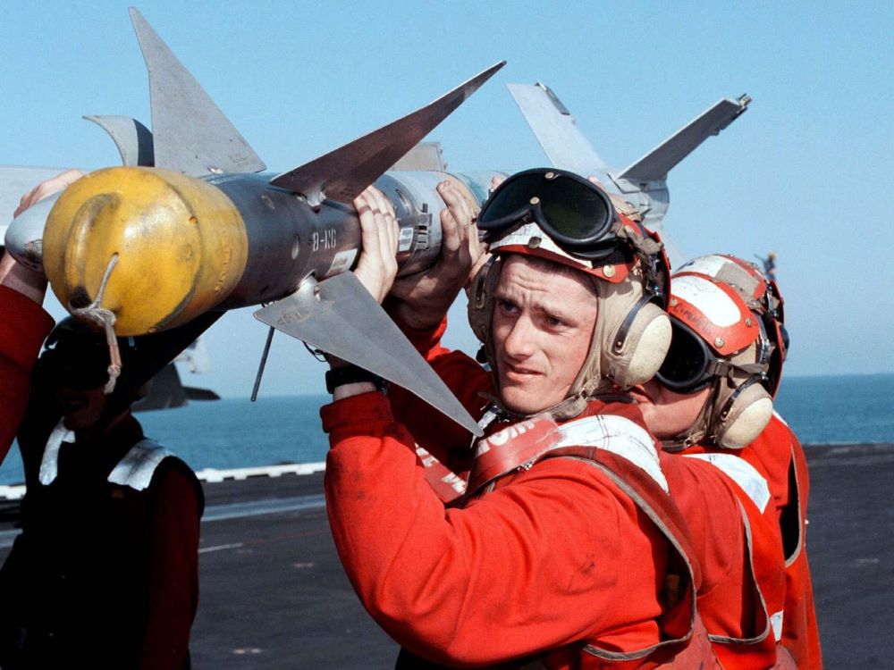 Aviation ordnance workers load a ''Sidewinder'' air-to-air missile onto a jet fighter aboard the USS George Washington in the Persian Gulf Feb. 19, 1998, during Operation Southern Watch. (CNS/Reuters)