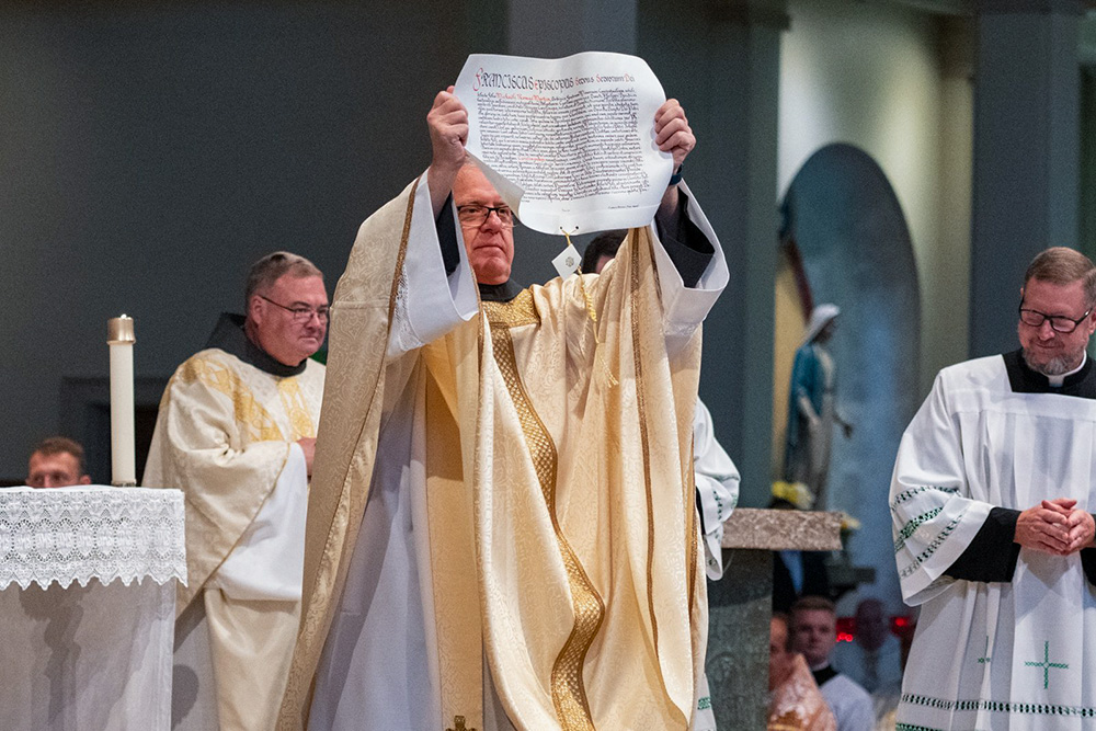 Bishop Michael Martin displays the papal bull from Pope Francis appointing him to head the Diocese of Charlotte, N.C., during his ordination and installation Mass at St. Mark Church in Huntersville, N.C., May 29, 2024. (OSV News/Catholic News Herald/Troy Hull)
