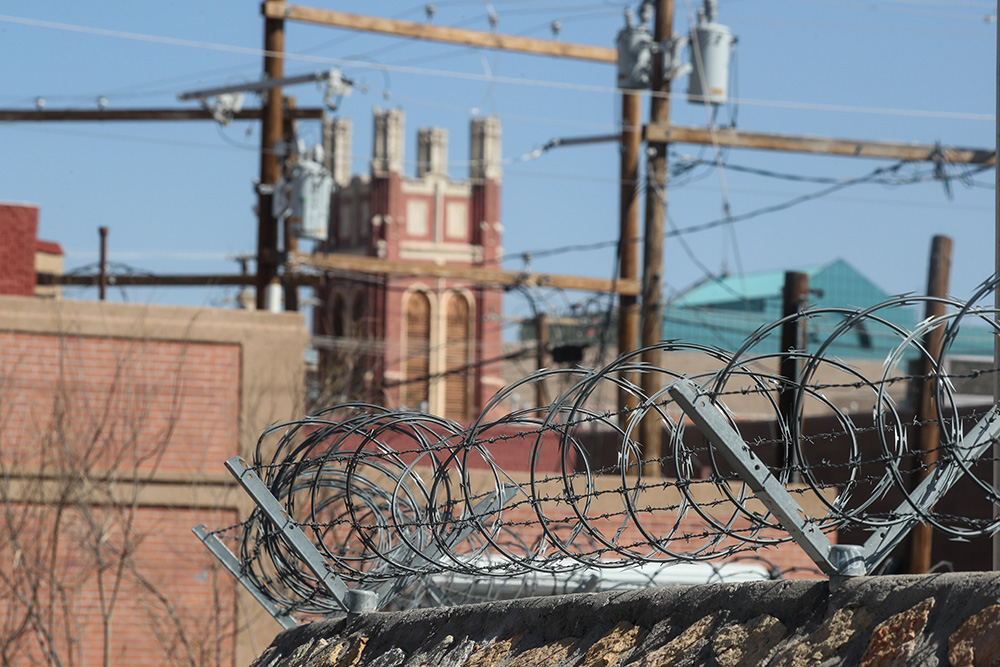 Razor wire is seen at the port of entry in El Paso, Texas, March 24, 2025. Sacred Heart Catholic Church can be seen in the distance. (OSV News/Bob Roller)