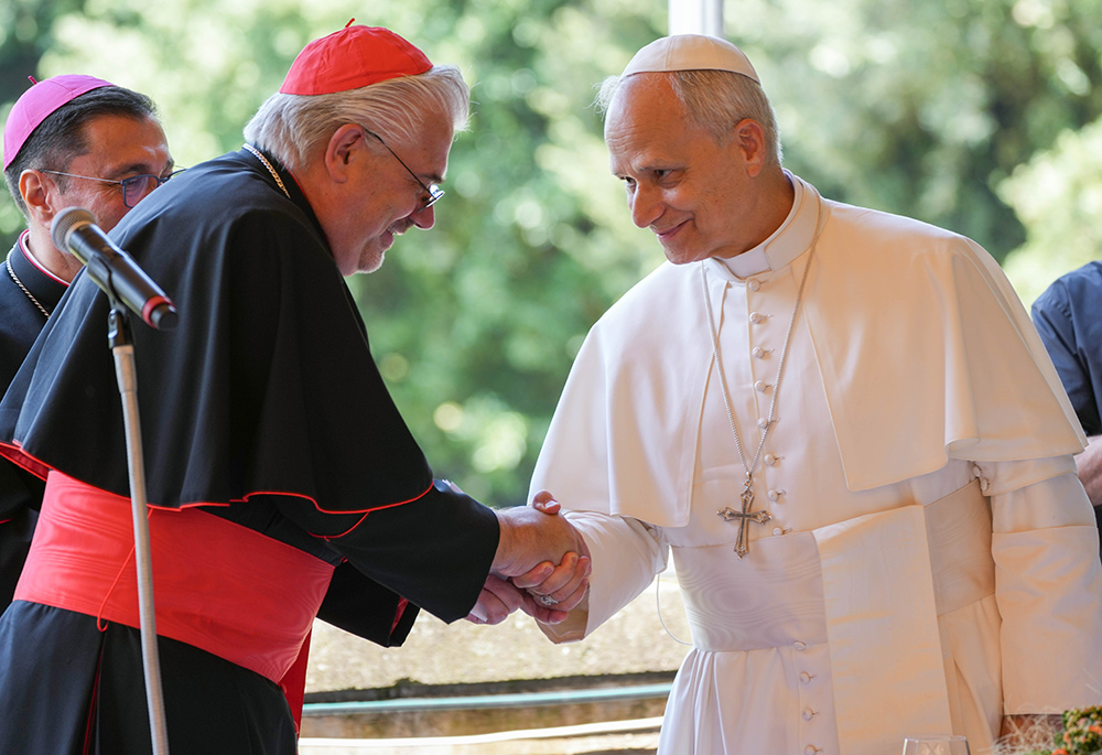 Pope Leo XIV shakes hands with Cardinal Fabio Baggio, undersecretary of the Dicastery for Promoting Integral Human Development, at the start of a luncheon with guests assisted by the Albano diocesan Caritas agency at the Borgo Laudato Si’ in Castel Gandolfo, Italy, Aug. 17, 2025. (CNS/Lola Gomez)