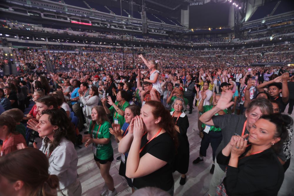 A young pilgrim watches from her father's shoulders as Dave and Lauren Moore and others perform July 19, 2024, during the third revival night of the National Eucharistic Congress at Lucas Oil Stadium in Indianapolis. (OSV News/Bob Roller)