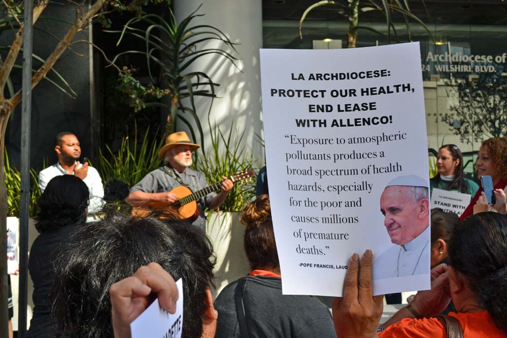A demonstrator holds up a sign with a passage from Pope Francis' encyclical "Laudato Si', on Care for Our Common Home" during a protest Oct. 4, 2017, outside the chancery of the Los Angeles Archdiocese. Approximately 50 people attended the demonstration, urging the archdiocese to cancel a land lease agreement allowing oil drilling within a south LA neighborhood. (Courtesy of STAND-L.A.)