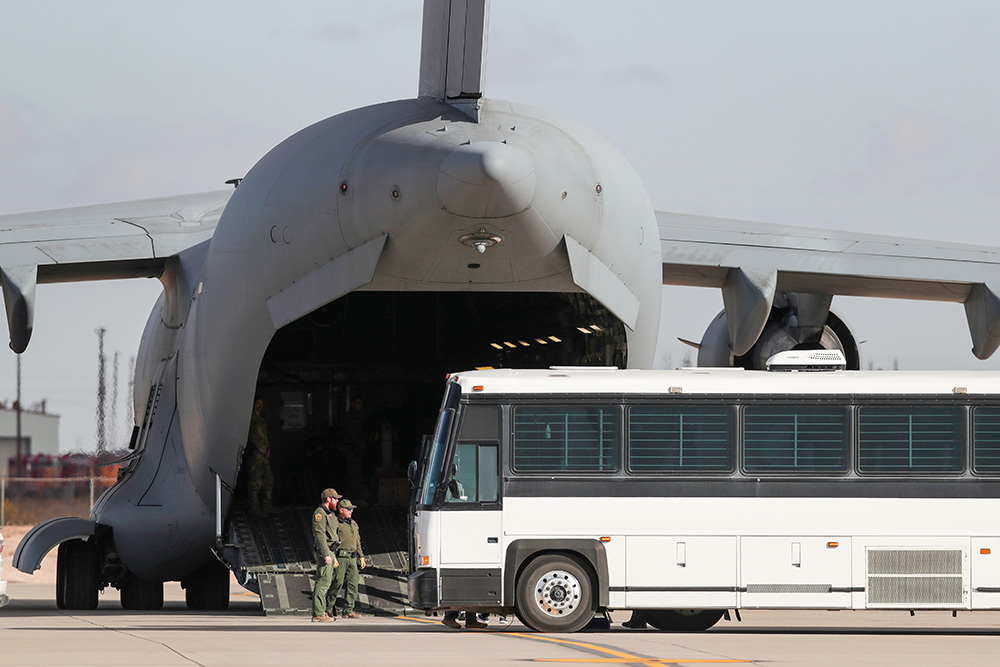 A military aircraft waits for migrants to board from a bus at Fort Bliss in El Paso, Tx., Thursday, Jan. 30, 2025, before deporting them to Guatemala. (AP/Christian Chavez, File)