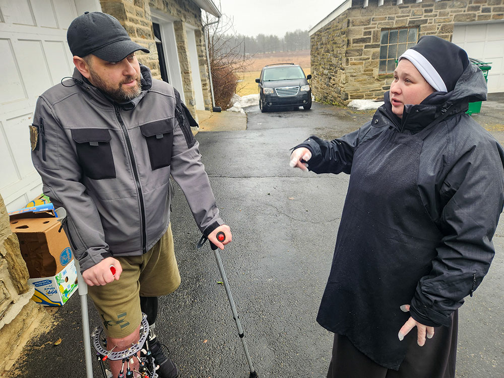 Basilian Sr. Anna Andrusiv, right, who arrived in Jenkintown, Pa., in September after taking final vows in the Ukrainian capital of Kyiv in August, speaks to Ihor Kozak, 40, a Ukrainian soldier undergoing medical treatment at the University of Pennsylvania hospitals. (GSR photo/Chris Herlinger)