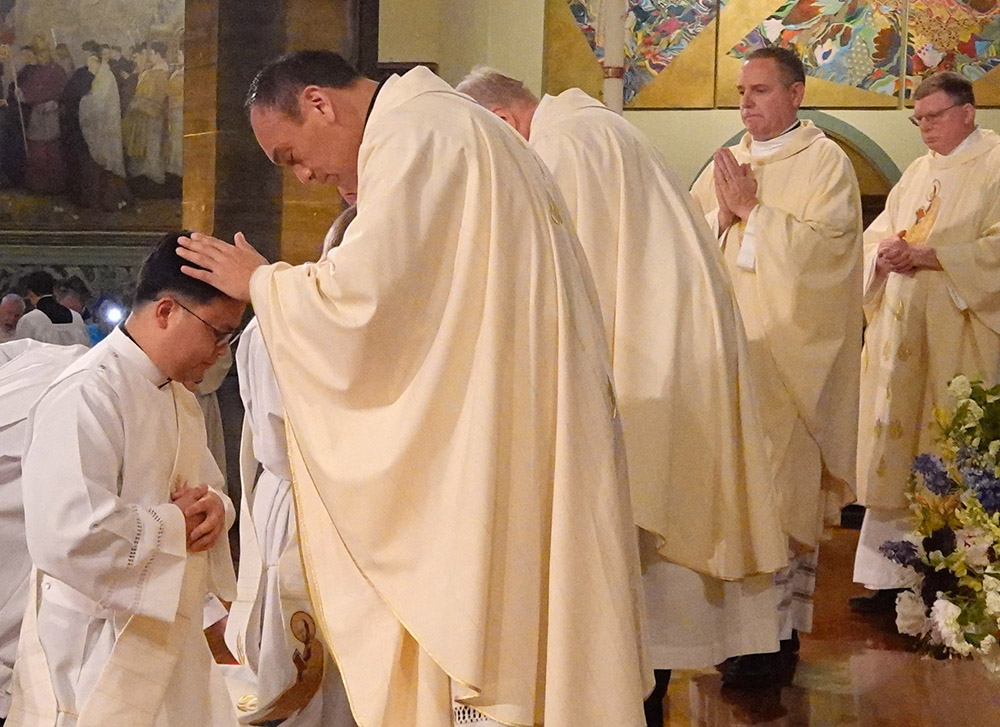 Paulist Fr. René Constanza blesses Paulist Fr. Dan Macalinao during his ordination in May 2024. (Courtesy of Paulist Fathers)