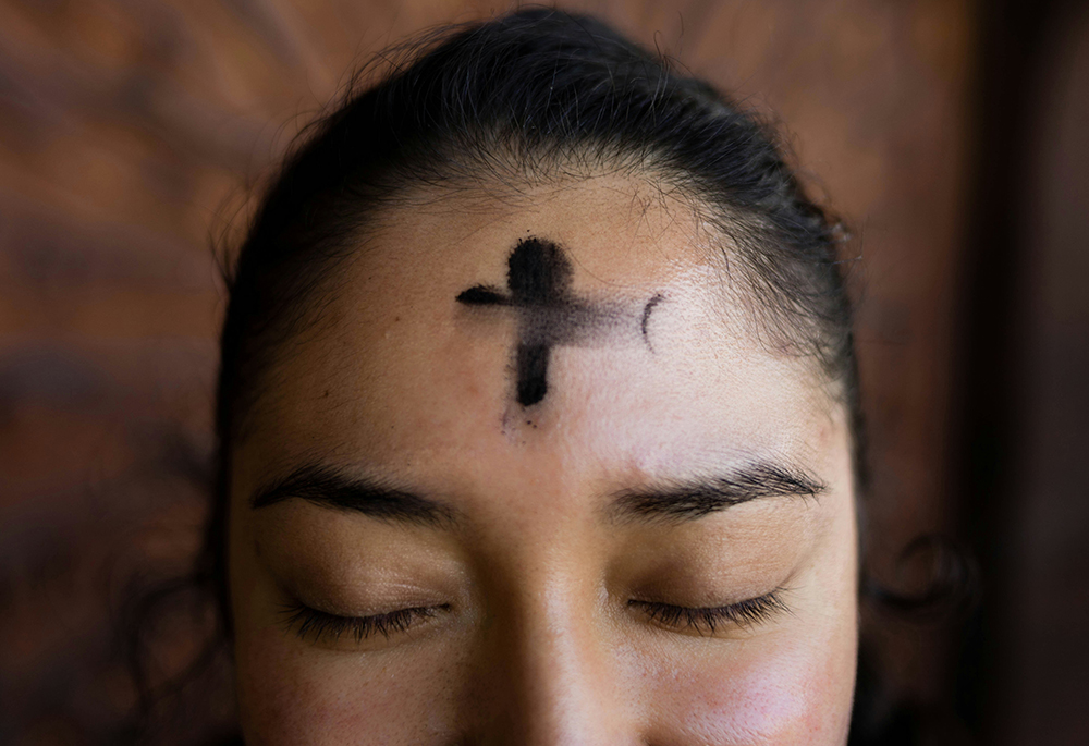 A close-up shows a person's forehead with a cross made of ashes. (Unsplash/Annika Gordon)