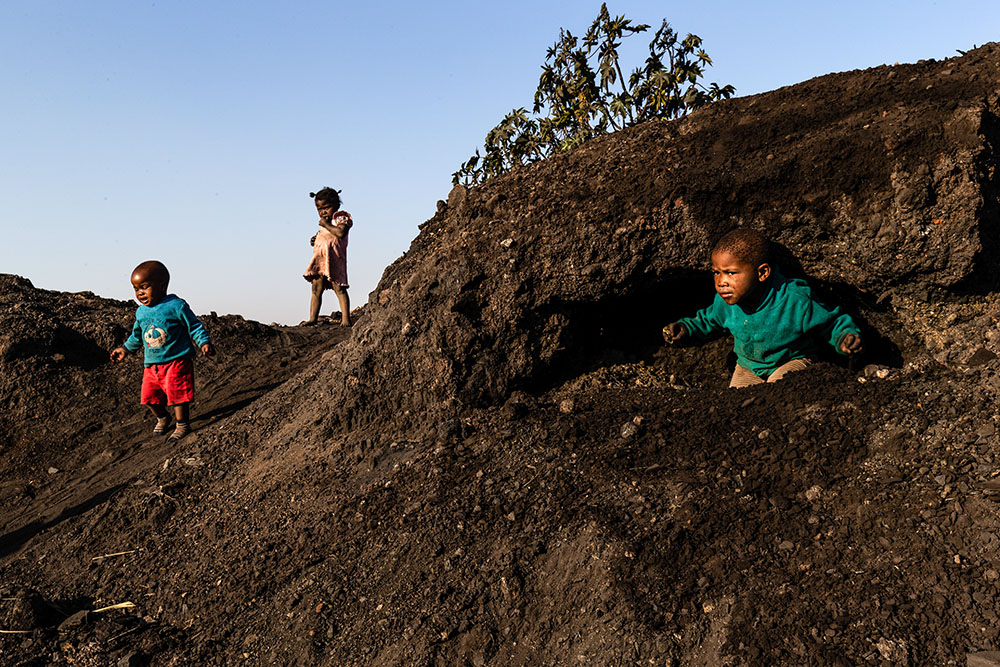 Children play in the midst of a coal mine dump in Emalahleni, South Africa, June 28, 2019. Many of the youngest have severe respiratory diseases. (Newscom/ZUMAPRESS/Stefan Kleinowitz)