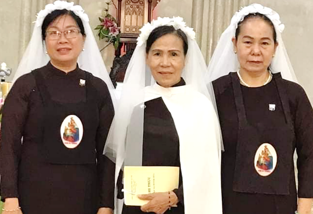 María Madeline Do Thi Ngoc, en el centro, y otras dos miembros laicas de la Orden del Carmelo posan para una foto en su ceremonia de toma de votos en Hue, Vietnam, el 19 de marzo de 2025. (Foto: Joachim Pham)