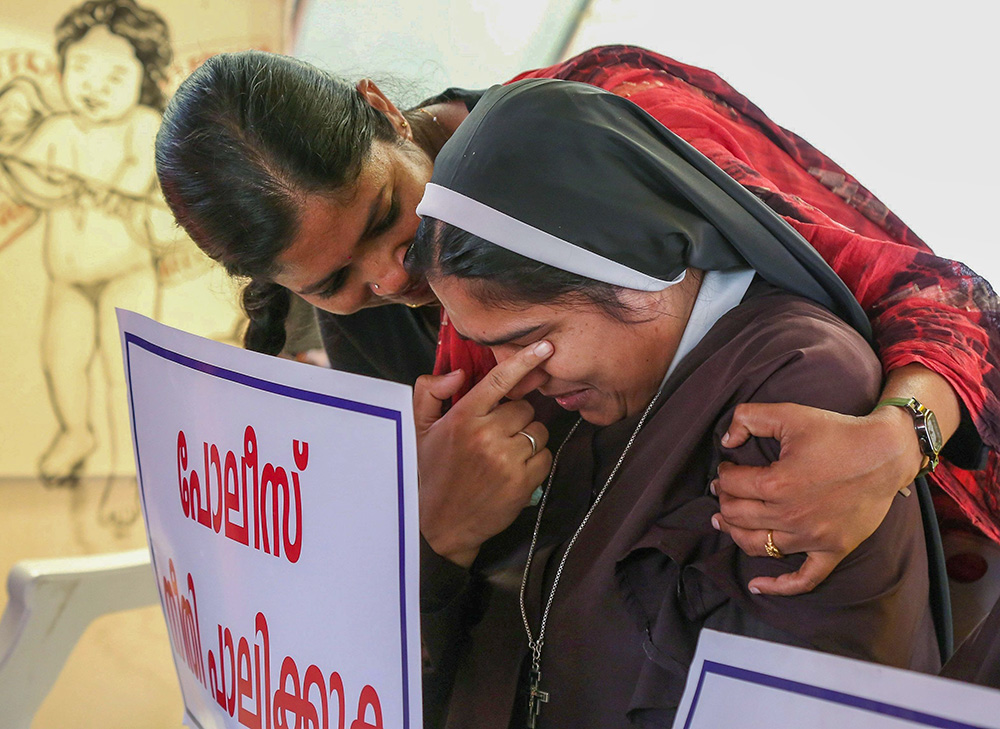 A nun is consoled during a protest on Sept. 13, 2018, in Cochin, India. The protest was to demand justice after a former religious superior accused Bishop Franco Mulakkal of Jalandhar of raping her. Indian nuns questioned the church's silence in the rape case and expressed support for the complainant nun after a court acquitted Mulakkal of all charges Jan. 14, 2022. (CNS/Reuters/Sivaram V)