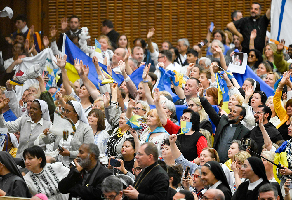 Participants wave Ukrainian flags as Pope Leo XIV greets them during the Jubilee of the Eastern Churches in the Paul VI Audience Hall at the Vatican May 14, 2025. (CNS/Vatican Media)
