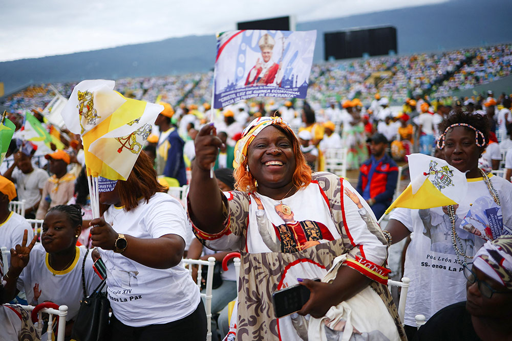 A woman waves a flag with an image of Pope Leo XIV ahead of the pontiff's arrival to celebrate the final Mass of his apostolic journey to Africa at Malabo Stadium in Equatorial Guinea April 23, 2026. (OSV News/Reuters/Guglielmo Mangiapane)