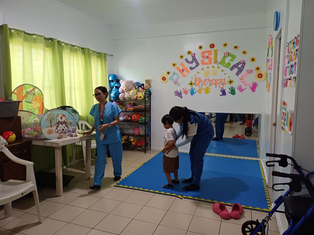 A therapist assists a child during a physical therapy session at the Sacred Heart Center, where more than 60 children a week with autism, Down syndrome, ADHD and other developmental conditions receive support, therapy and care. (Oliver Samson)