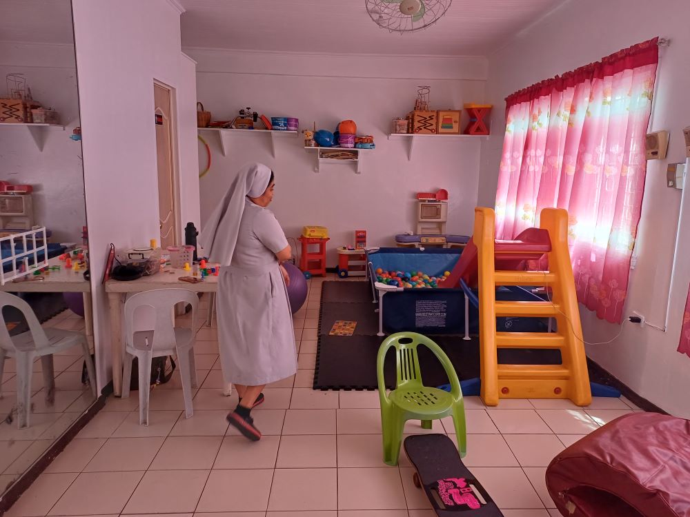 Sr. Eleanor Rosare walks through a play and therapy room at the Sacred Heart Center in Quezon City, Philippines. The Daughters of St. Mary of Providence run the center, where more than 60 children a week with autism, Down syndrome, ADHD and other developmental conditions receive support, therapy and care. (Oliver Samson) 