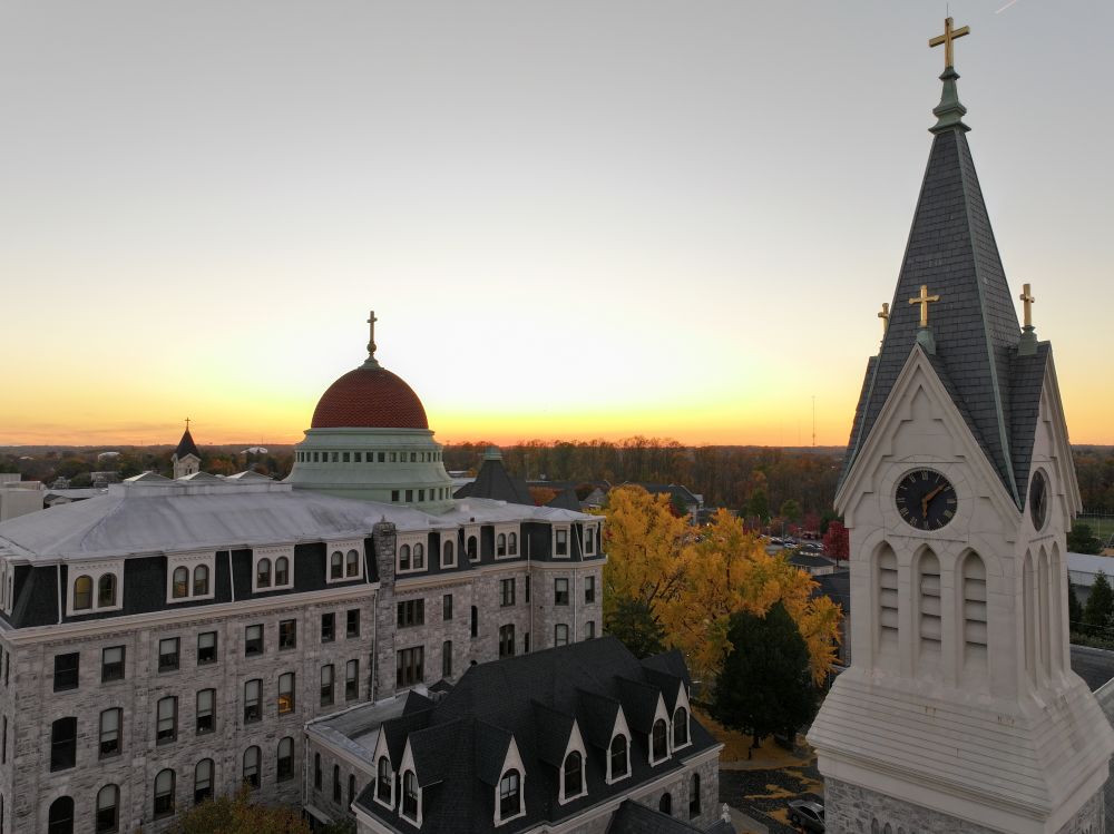 The motherhouse of the Sisters of St. Francis of Philadelphia (left) is seen at sunset. The sisters sold the motherhouse, other buildings and 63 acres to Neumann University which rents space to the sisters for an office, meeting space and housing for about 30 sisters. One wing is now student housing for Neumann, with about 60 students residing there. (Courtesy of the Sisters of St. Francis of Philadelphia)