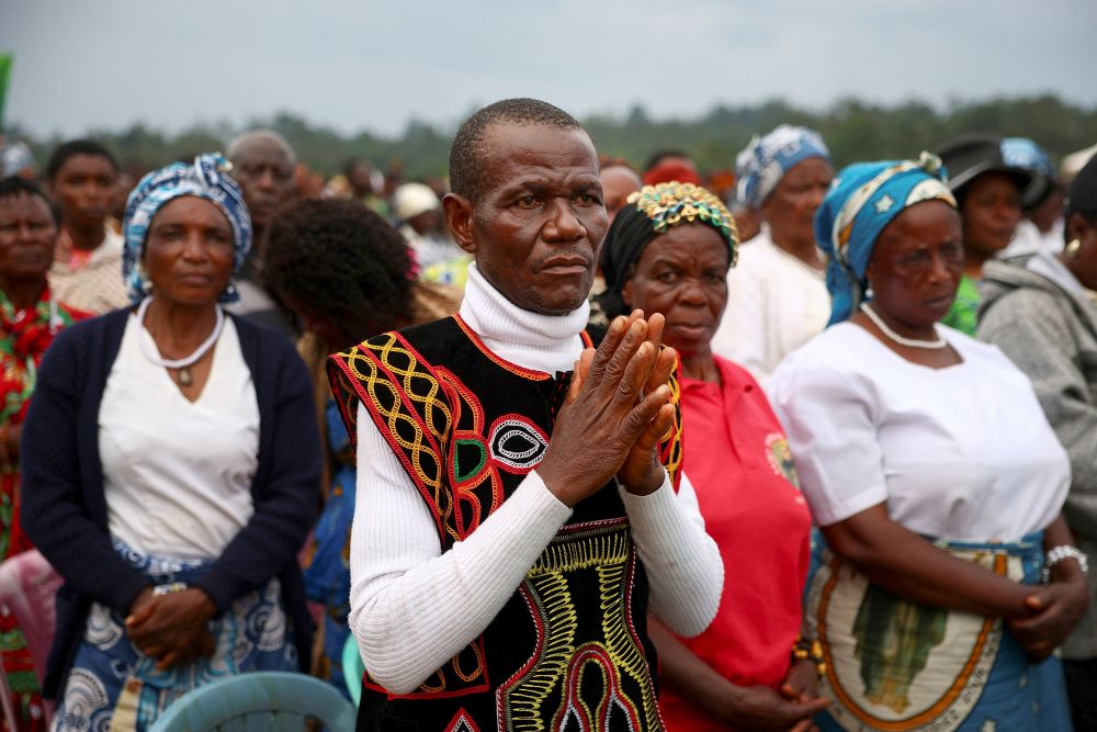 A man prays as Pope Leo XIV celebrates Mass at Bamenda International Airport in Cameroon April 16, 2026. (OSV News/Reuters/Guglielmo Mangiapane)